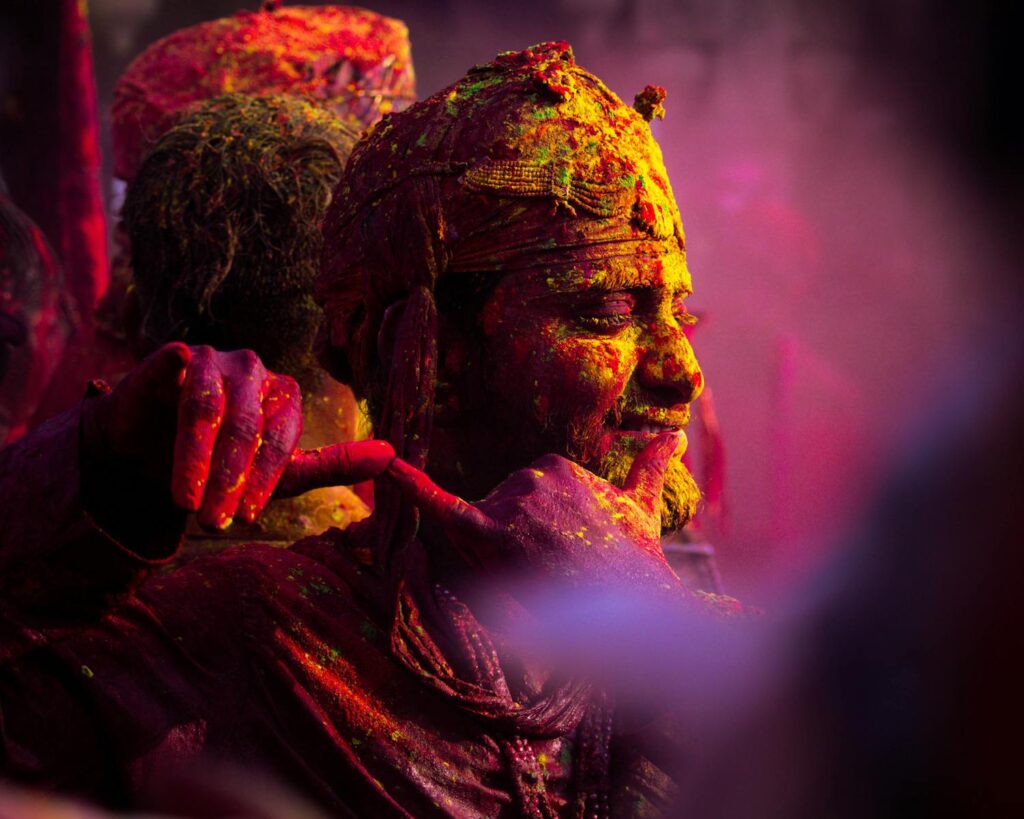 Colorful Holi celebration in Vrindavan with people covered in vibrant powder.